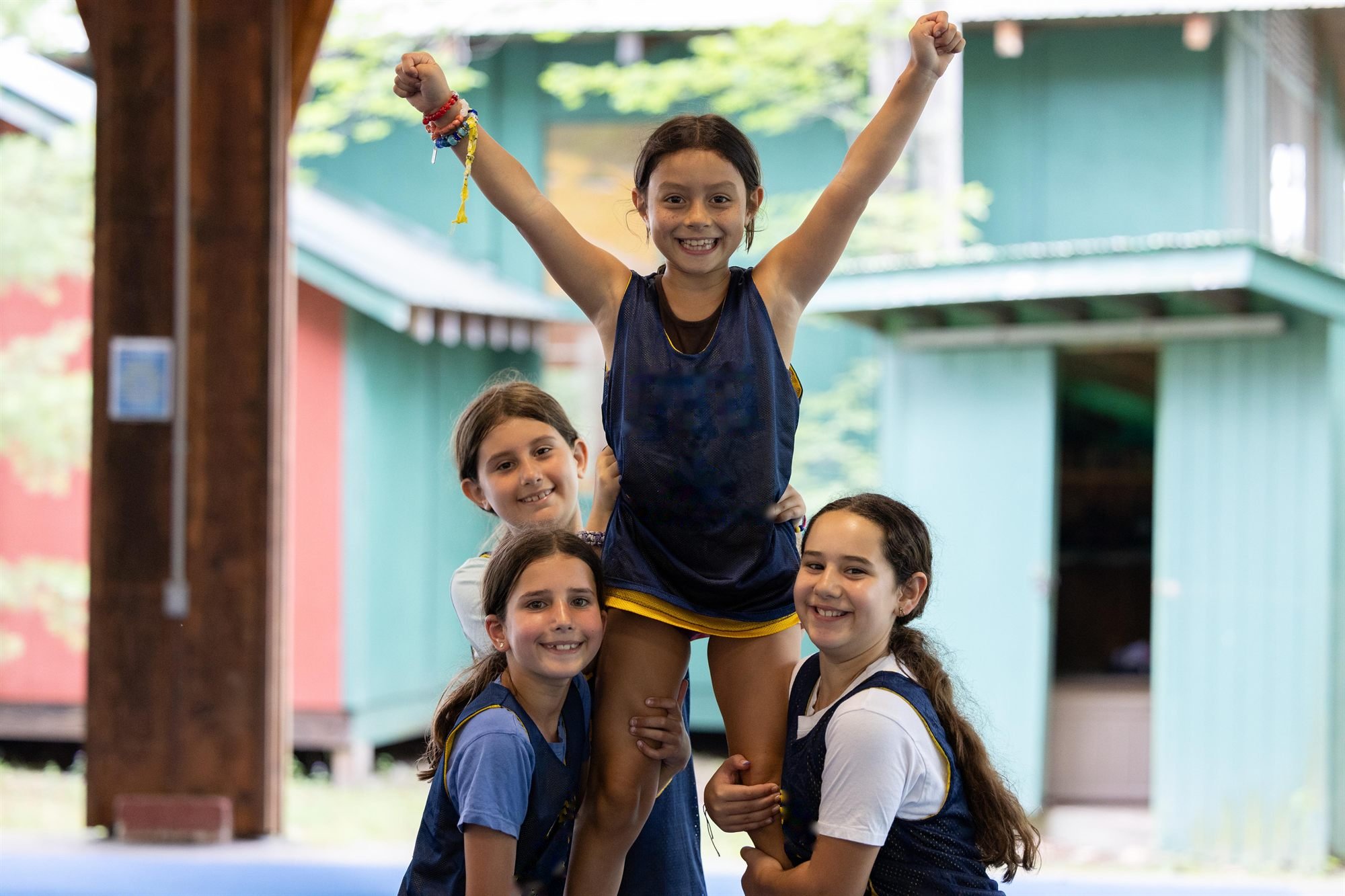 Campers stacked in a human pyramid outside the cabins