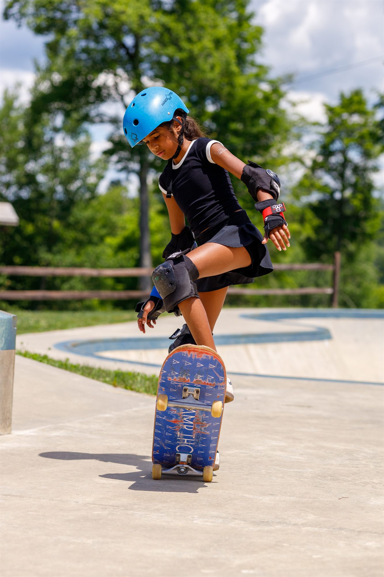 A camper riding a skateboard at the skate park
