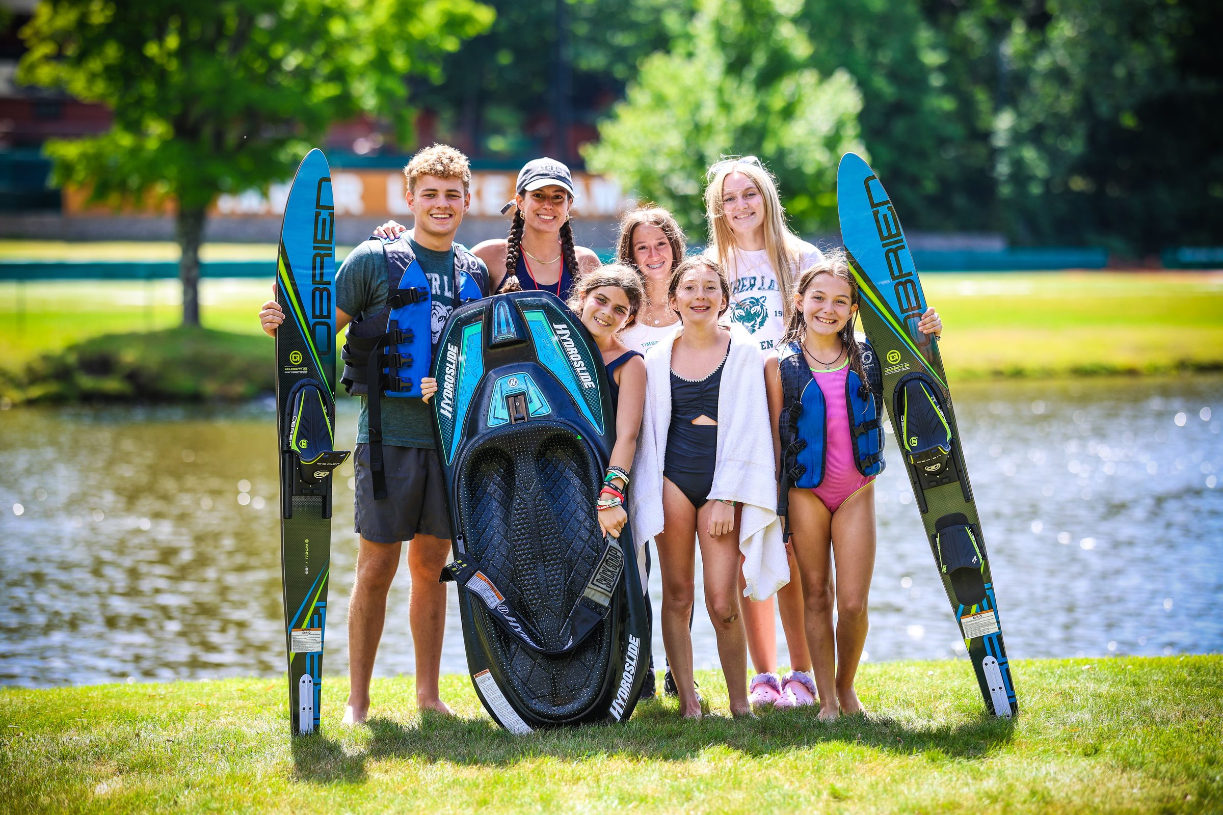 A line of campers holding their water skis by the lake