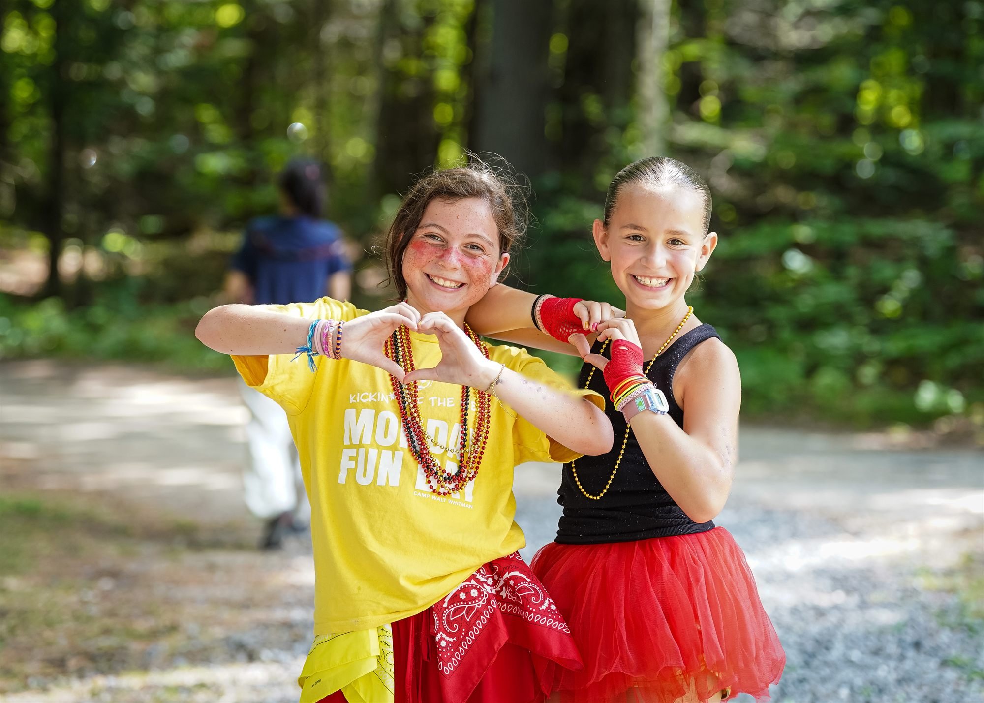 Two campers in bright costumes laughing together outdoors