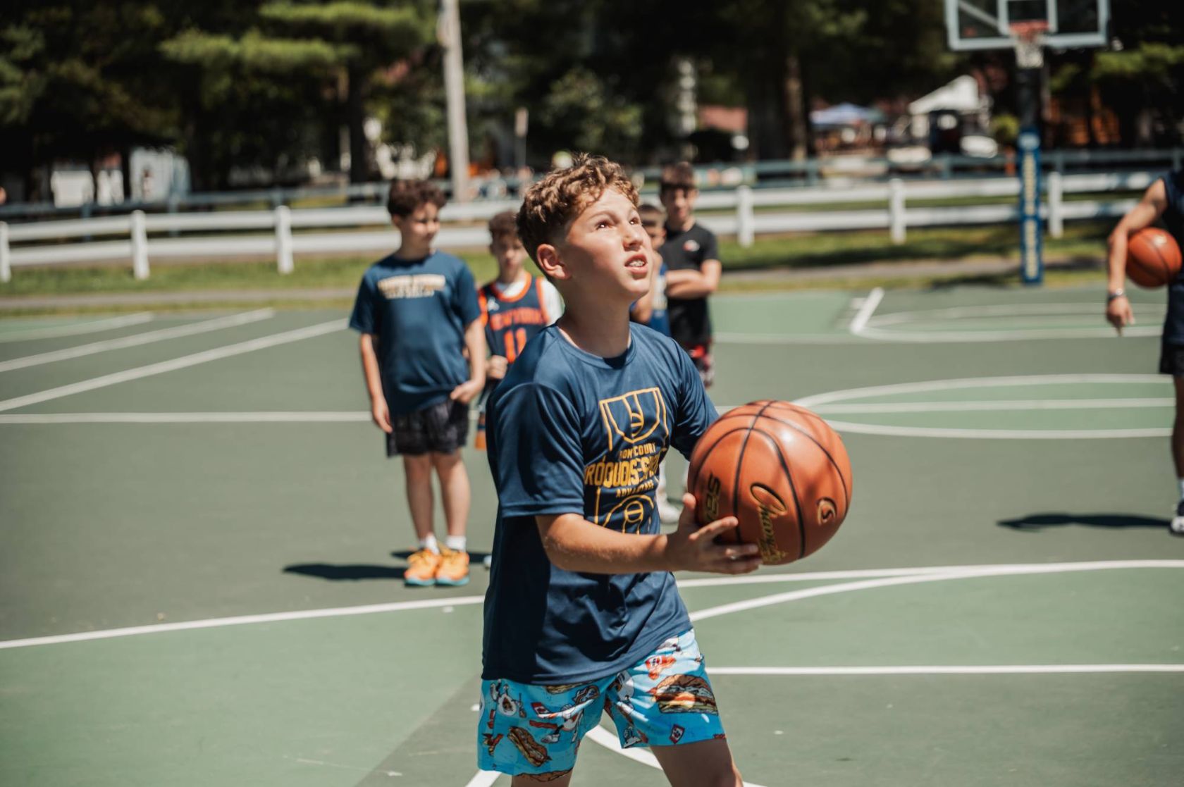 A camper lining up a shot on the basketball court at sports camp