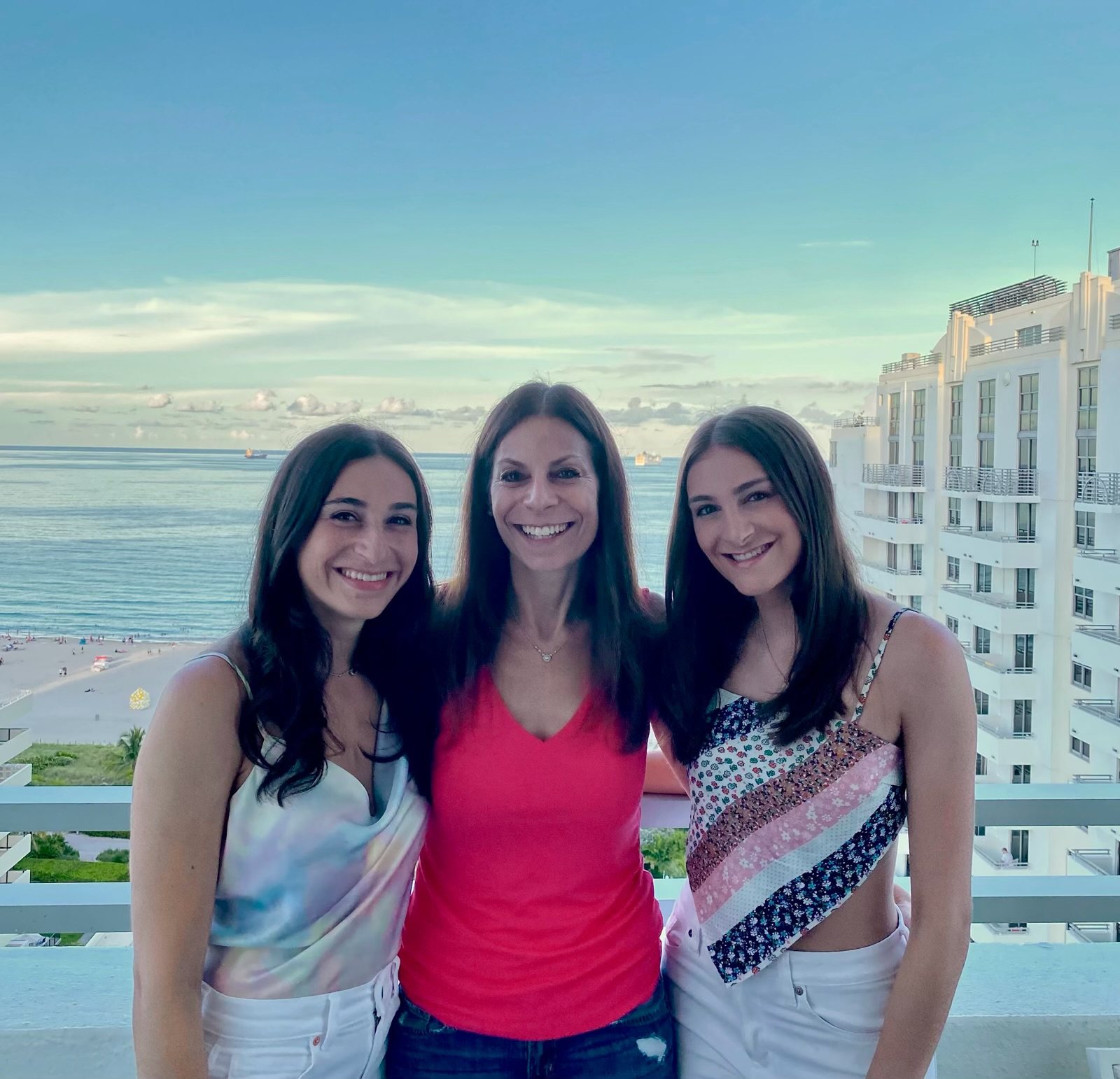 Stacy Blicht with her two daughters on a balcony overlooking the beach